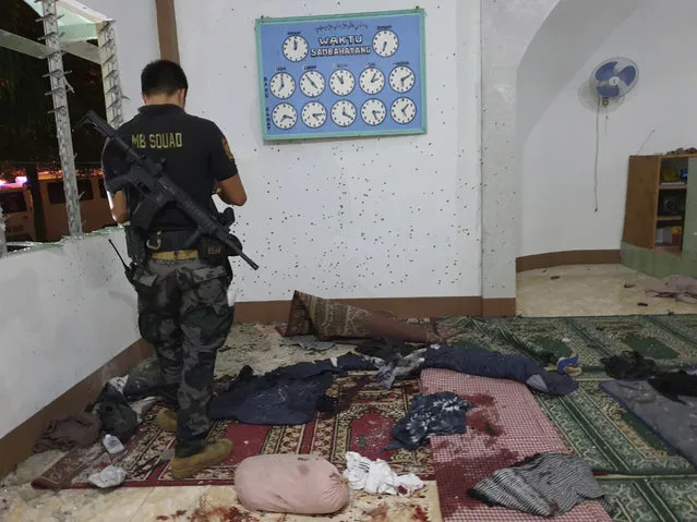 In this photo provided by WESMINCOM Armed Forces of the Philippines, a police investigator examines the scene of a grenade attack of a Muslim mosque in Zamboanga city in southern Philippines early Wednesday, January 30, 2019. The attack came after suspected militants exploded two bombs at a Roman Catholic Cathedral in southern Jolo, Sulu province, during a Sunday Mass. (Photo by WESMINCOM Armed Forces of the Philippines via AP Photo)