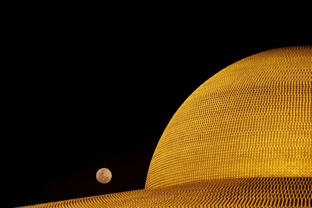 The full moon is seen over the Buddhist Wat Phra Dhammakaya temple during a ceremony on Makha Bucha Day in Pathum Thani province, north of Bangkok February 22, 2016. (Photo by Jorge Silva/Reuters)
