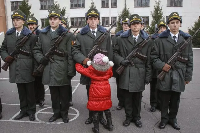 A girl hugs her brother, a recruit from the presidential regiment, as he takes the oath at a military base in Kiev November 16, 2013. (Photo by Gleb Garanich/Reuters)