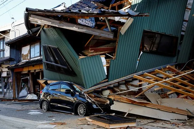 A damaged car stands near a collapsed house, following an earthquake, in Nanao, Ishikawa prefecture, Japan on January 2, 2024. (Photo by Kim Kyung-Hoon/Reuters)