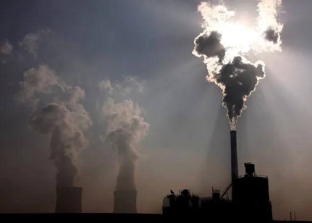 A coal-burning power plant can be seen behind a factory in the city of Baotou, in China's Inner Mongolia Autonomous Region October 31, 2010. (Photo by David Gray/Reuters)