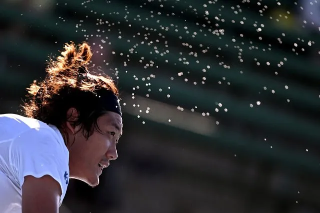 Sweat sprays from Zhang Zhizhen of China during his men's singles match against Frances Tiafoe of the US at the Kooyong Classic tennis tournment in Melbourne on January 10, 2024. (Photo by William West/AFP Photo)