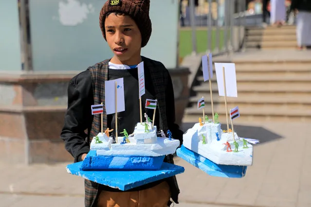 A Yemeni boy sells models of the Galaxy Leader cargo ship, seized by Huthi fighters in November 2023, in Sanaa on January 18, 2024. US and UK forces launched a fourth round of strikes against targets in Yemen, Huthi media said on January 18, as the Iran-backed rebels vowed to continue attacking Red Sea shipping. (Photo by Mohammed Huwais/AFP Photo)