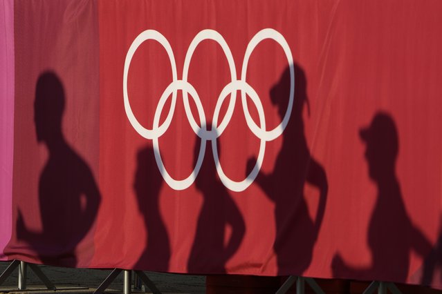 Athlete's shadows appear on a curtain during the men's 50km race walk at the 2020 Summer Olympics, Friday, August 6, 2021, in Sapporo, Japan. (Photo by Eugene Hoshiko/AP Photo)