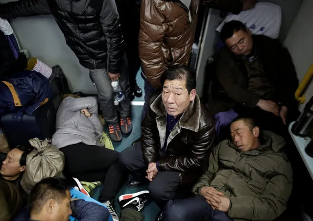 A man looks up as passengers sleep in a train from Xinjiang to Shanghai, ahead of the upcoming Spring Festival,  China, January 15, 2017. (Photo by Darley Shen/Reuters)