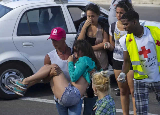 Members of the Cuban Red Cross help a young woman during a free concert by the U.S. electronic music group Major Lazer, at the Anti-Imperialist park in front of the U.S. Embassy in Havana, Cuba, Sunday, March 6, 2016. (Photo by Ramon Espinosa/AP Photo)