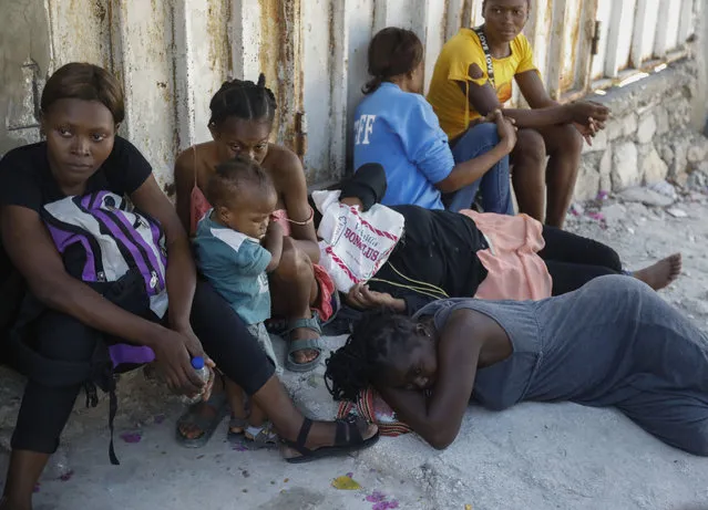 Residents of the Solino neighborhood, who were displaced from their homes due to clashes between armed gangs, rest on a street in the Carrefour community of Port-au-Prince, Haiti, Thursday, January 18, 2024. (Photo by Odelyn Joseph/AP Photo)