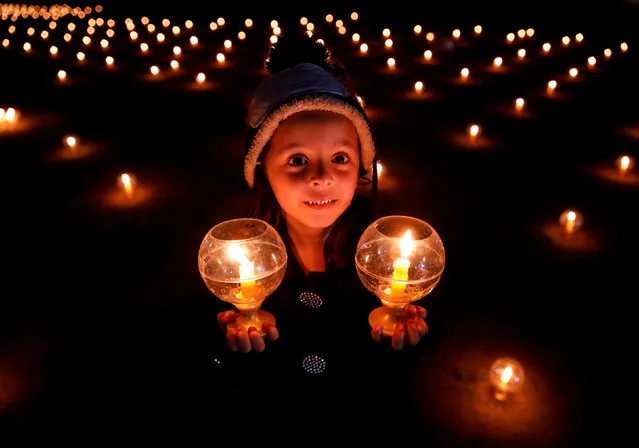 A girl with lit candles attends an event to spread the message of “world peace through inner peace” in Kathmandu, Nepal on March 16, 2019. (Photo by Navesh Chitrakar/Reuters)