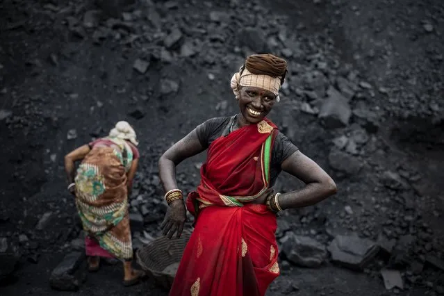 An Indian laborer smiles as she takes a break from loading coal into a truck in Dhanbad, an eastern Indian city in Jharkhand state, Friday, September 24, 2021. A 2021 Indian government study found that Jharkhand state – among the poorest in India and the state with the nation’s largest coal reserves – is also the most vulnerable Indian state to climate change. Efforts to fight climate change are being held back in part because coal, the biggest single source of climate-changing gases, provides cheap electricity and supports millions of jobs. It's one of the dilemmas facing world leaders gathered in Glasgow, Scotland this week in an attempt to stave off the worst effects of climate change. (Photo by Altaf Qadri/AP Photo)