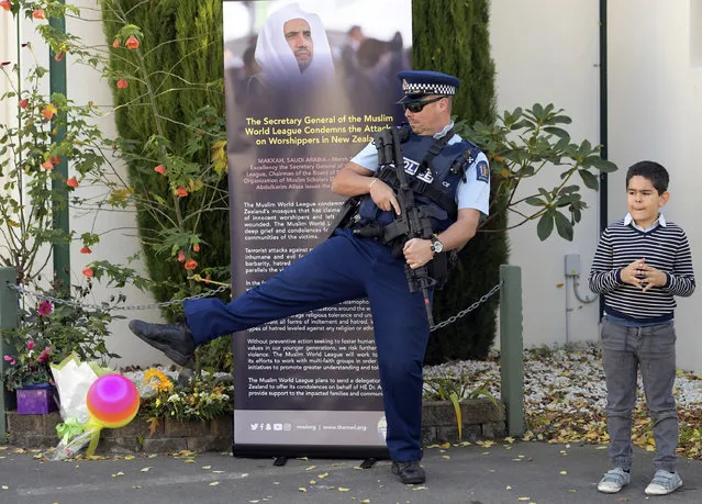 An armed police officer joins in with a children's ball game as they wait for Britain's Prince William at the Al Noor mosque in Christchurch, New Zealand, Friday, April 26, 2019. Prince William visited the one of the mosques where 50 people were killed and 50 others wounded in a March 15 attack by a white supremacist. (Photo by Tracey Nearmy/Pool via AP Photo)