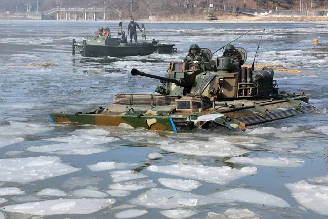 Soldiers riding in K-21 armored vehicles take part in a river-crossing drill at a training range in Pocheon, just 25 kilometers south of the inter-Korean border, South Korea, 24 January 2024, as the Army's Capital Mechanized Infantry Division conducts a wintertime exercise as part of efforts to strengthen its combat preparedness. (Photo by Yonhap/EPA)