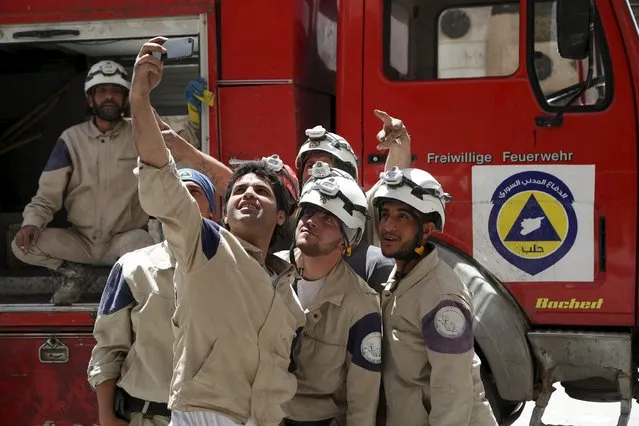 Civil defense members pose for a picture after they finished working at a damaged site hit by what activists said was shelling on Tuesday by forces loyal to Syria's President Bashar al-Assad in Aleppo's al-Aryan neighborhood April 30, 2015. (Photo by Hosam Katan/Reuters)