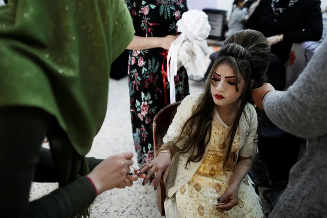 Chahad, 16, gets groomed at a beauty Salon in Kalak before her wedding party, Iraq February 16, 2017. (Photo by Zohra Bensemra/Reuters)