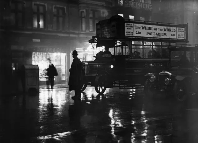 2nd December 1924:  A policeman holds up the traffic in Parliament Street to allow members of parliament to get to the House of Commons on a rainy winter evening.  (Photo by Topical Press Agency/Getty Images)