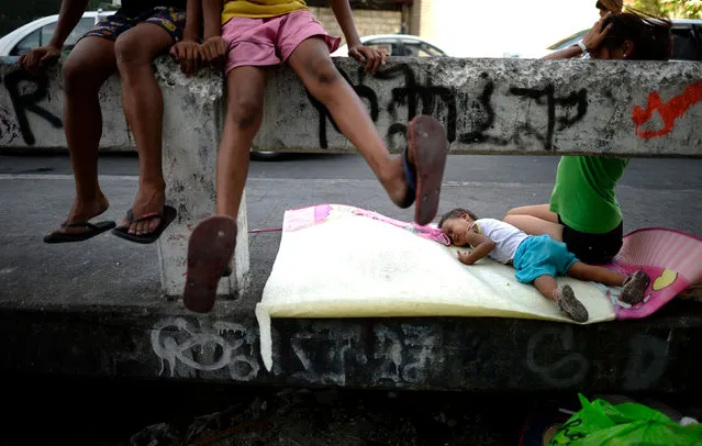 A child sleeps on a bridge in Manila on April 6, 2016. Roughly one quarter of the nation's 100 million people live in poverty, which is defined as surviving on about one US dollar a day, according to government data. (Photo by Noel Celis/AFP Photo)