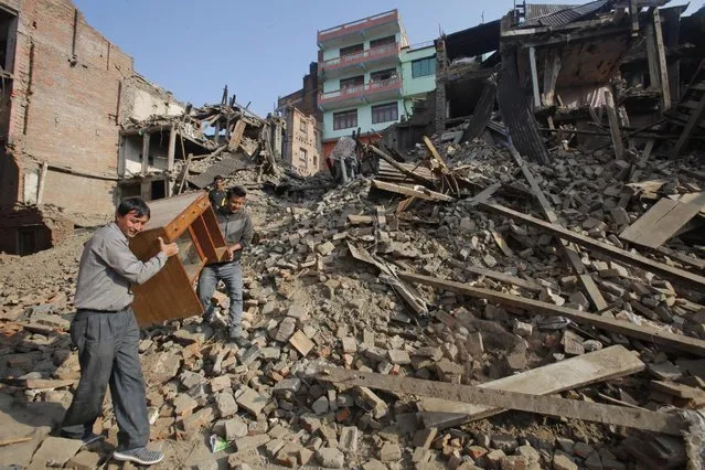 Nepalese people recover their belongings from earthquake destroyed buildings in Bhaktapur, Nepal, Thursday, May 14, 2015. (Photo by Bikram Rai/AP Photo)