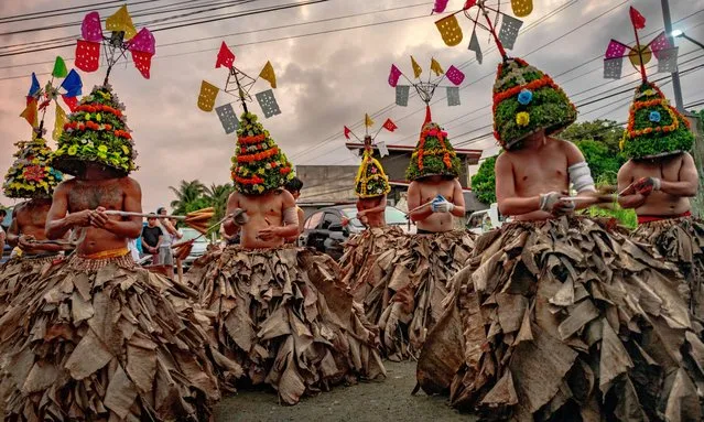 Flagellants wearing dried banana leaves and colorful headdresses whip their backs during Good Friday Lenten Rites on March 29, 2024 in Infanta, Quezon province, Philippines. Although the act of self mortification is condemned by the Catholic church and frowned upon in the modern age, thousands of Filipino faithful still practice it to this day as a form of popular piety and has become a part of Philippine tradition in Asia's largest predominantly Roman Catholic nation. (Photo by Ezra Acayan/Getty Images)