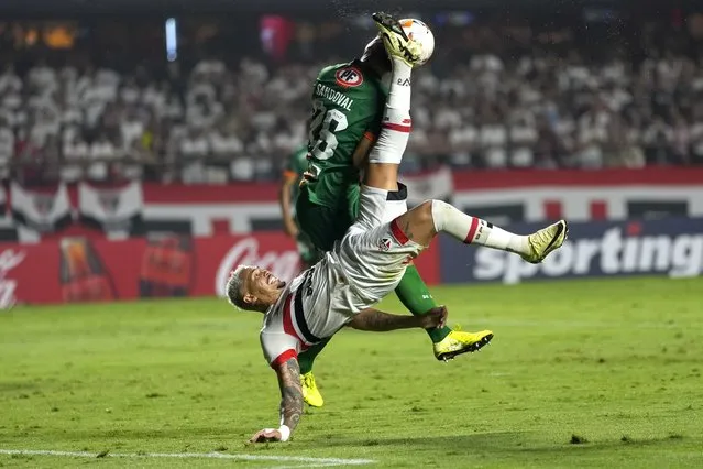 Luciano of Brazil's Sao Paulo, bottom, and Rodrigo Sandoval of Chile's Cobresal, battle for the ball during a Copa Libertadores Group B soccer match at the Morumbi stadium in Sao Paulo, Brazil, April 10, 2024. (Photo by Andre Penner/AP Photo)