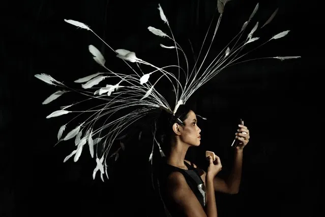 A model presenting creations by Arjun Putra checks her make-up at the back of the stage during the Indonesia Fashion Week at the Jakarta Convention Center in Jakarta on March 31, 2024. (Photo by Yasuyoshi Chiba/AFP Photo)