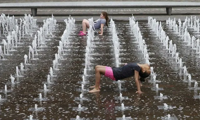 Children play in the fountains outside Central St Martins in London, Britain May 19, 2015. (Photo by Suzanne Plunkett/Reuters)