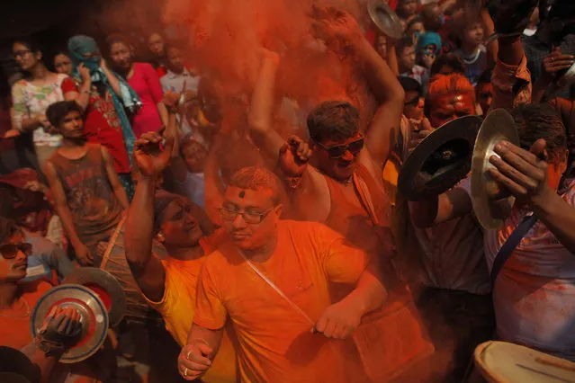 Nepalese devotees throw 'sindoor' or vermillion powder during Sindoor Jatra festival in Bhaktapur, Nepal, Thursday, April 14, 2016. Devotees mark the festival by playing traditional drums, singing, dancing and carrying chariot of various deities around town while throwing vermillion powder to welcome the advent of spring and the New Year. (Photo by Niranjan Shrestha/AP Photo)