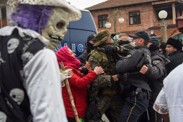 Police try to disperse revelers at the end of the carnival parade through the south-western North Macedonia village of Vevcani on January 13, 2021. The Vevcani carnival is 1.400 years old and is held every year on the eve of the feast of Saint Basil ( January 14), which also marks the beginning of the New Year according to the Julian calendar, observed by the Macedonian Orthodox Church. (Photo by Robert Atanasovski/AFP Photo)