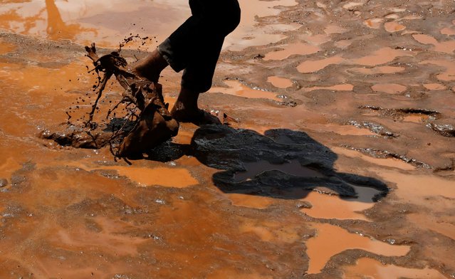 A boy walks through muddy water after heavy flash floods wiped out several homes when a dam burst, following heavy rains in Kamuchiri village of Mai Mahiu, Nakuru County, Kenya on April 29, 2024. (Photo by Thomas Mukoya/Reuters)