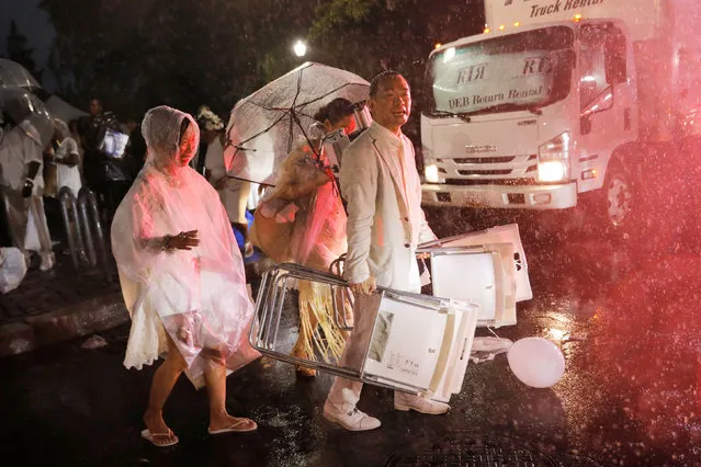 Attendees evacuate as heavy rain falls at the 2019 NYC Diner en Blanc dining event in New York, U.S., July 17, 2019. (Photo by Andrew Kelly/Reuters)