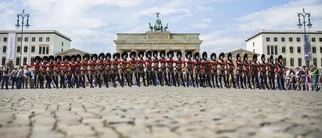 Dancers of the Friedrichstadt-Palast from the show “THE WYLD” pose during a promotional photocall in front of the Brandenburg Gate in Berlin, Germany, June 25, 2015. (Photo by Hannibal Hanschke/Reuters)