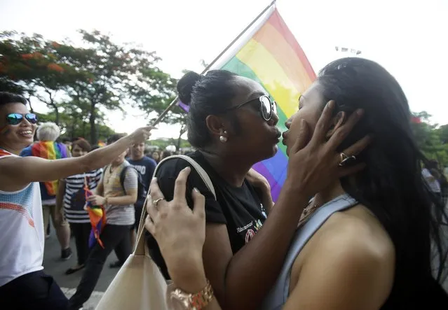 Filipino LGBTs (Lesbians Gays Bisexual and Transgenders) kiss as they gather for a Gay Pride rally Saturday, June 27, 2015 in Manila, Philippines, to push for LGBT rights and to celebrate the U.S. Supreme Court decision recognizing gay marriages in all U.S. states as a victory for their cause. The rally was scheduled to commemorate the 1969 demonstrations in New York City that started the gay rights movement around the world. (Photo by Bullit Marquez/AP Photo)