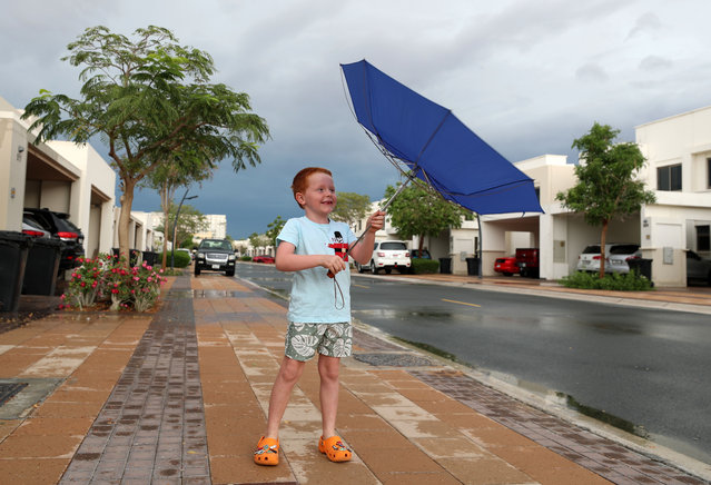 A young boy goes for a walk on a rainy day in Dubai on April 16, 2024. (Photo by Chris Whiteoak/The National)