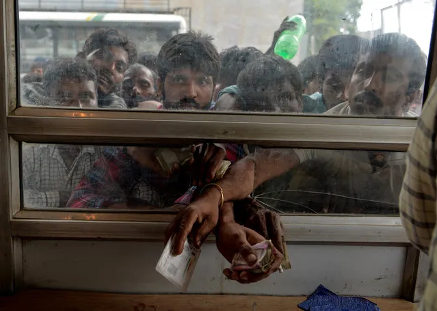 Labourers buy bus tickets at a counter of Jammu and Kashmir Tourist Reception Centre (JKTRC) in Srinagar on August 7, 2019. A protester died after being chased by police during a curfew in Kashmir's main city, left in turmoil by an Indian government move to tighten control over the restive region, a police official said on August 7. (Photo by Sajjad Hussain/AFP Photo)