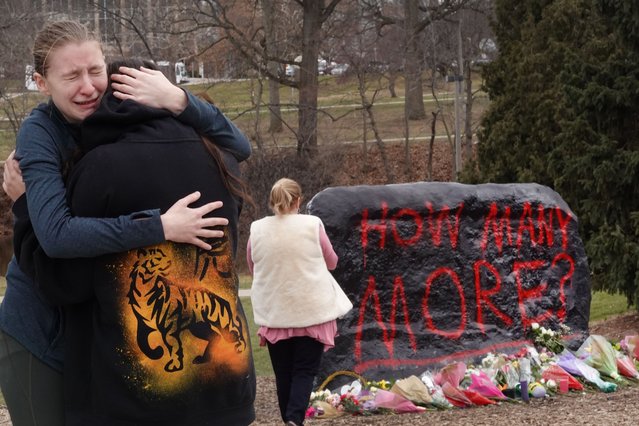People leave flowers, mourn and pray at a makeshift memorial at “The Rock” on the campus of Michigan State University on February 14, 2023 in East Lansing, Michigan. A gunman opened fire at two locations on the campus last night killing three students and injuring several others. (Photo by Scott Olson/Getty Images)