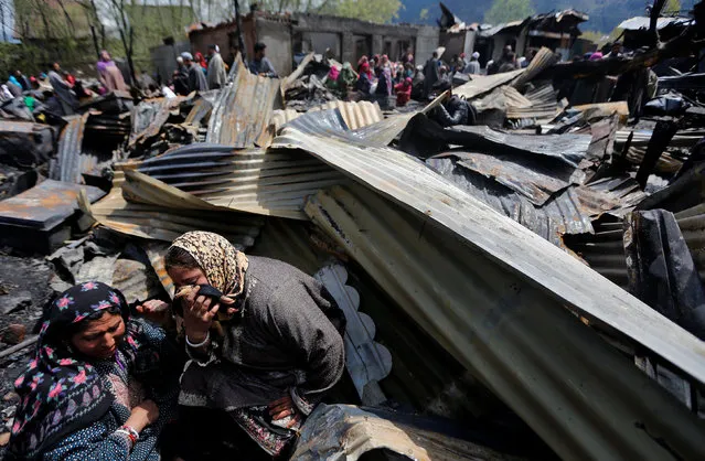 Women weep as they sit around remains of their houses gutted in a fire which broke out in a residential area on Tuesday, in Srinagar, April 5, 2017. (Photo by Danish Ismail/Reuters)