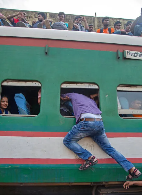 A man try to enter into an overcrowded train as he travel to celebrate Eid with family in the villages, at the Kamlapur Railway Station in Dhaka, Bangladesh, 03 June 2019. (Photo by Monirul Alam/EPA/EFE)