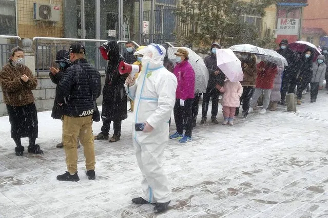 Residents line up for coronavirus screening during the COVID-19 lockdown in Changchun in northeastern China's Jilin province Saturday, March 12, 2022. (Photo by Chinatopix via AP Photo)