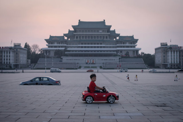 In a photo taken on September 9, 2019 a child drives a miniature electric toy car across Kim Il Sung square in Pyongyang. North Korea was marking the 71st anniversary of its foundation, with a public holiday. (Photo by Ed Jones/AFP Photo)
