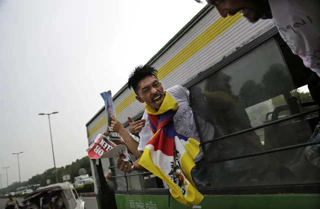 A Tibetan exile shouts slogans from inside a bus after being detained outside the Chinese embassy during a protest against the death of Tibetan lama Tenzin Delek Rinpoche, 65, who passed away in custody in a Chinese prison on July 12, in New Delhi, India, Friday, July 17, 2015. Chinese authorities cremated the body of the Tibetan lama in a prison Thursday against the wishes of his family, who had wanted to perform Buddhist funeral rites on the body in his hometown, a rights group said. (Photo by Altaf Qadri/AP Photo)
