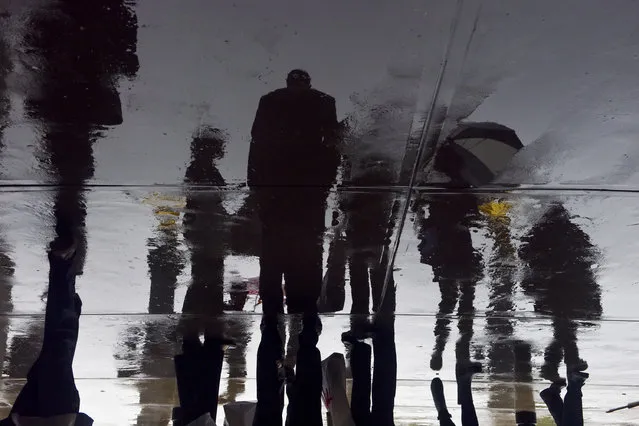 In an image rotated 180 degrees, commuters pass through Union Station as rain falls on the nation's capital on Thursday, May 11, 2017, in Washington, DC. (Photo by Jahi Chikwendiu/The Washington Post)