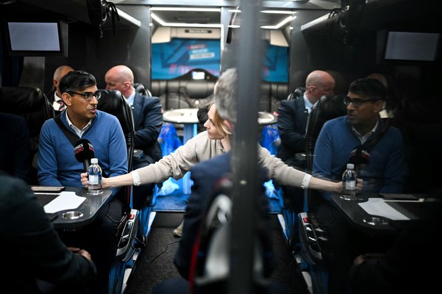 Britain's Prime Minister and Conservative Party leader, Rishi Sunak (L) speaks with journalists aboard of the party campaign bus on its way to Grimsby after leaving Doncaster Station, on the M180, on June 12, 2024, in the build-up to the UK general election on July 4. (Photo by Oli Scarff/Pool via AFP Photo)