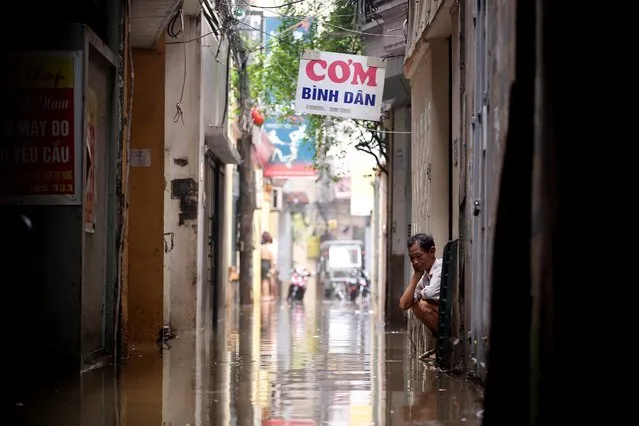 A man sits by a flooded alley in Hanoi, Vietnam, 25 May 2016. Heavy rain since the day before caused flooding and made many streets impassable in Hanoi, according to local media. (Photo by Luong Thai Linh/EPA)