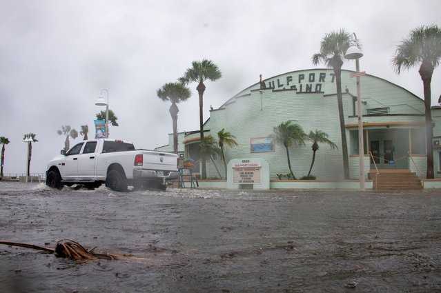 A vehicle drives through a flooded street as Debby, which strengthened into a hurricane Sunday night, approaches Gulfport, Fla. on August 4, 2024. (Photo by Dylan Townsend/Tampa Bay Times/AP Photo)