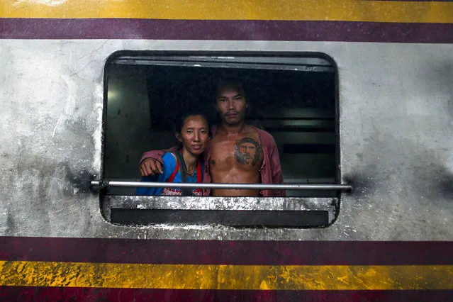 A couple pose at a window from the kitchen car in a train before departing at Hua Lamphong station in Bangkok, Thailand October 16, 2016. (Photo by Jorge Silva/Reuters)