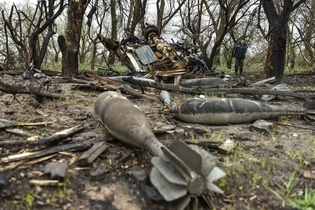A local man looks at rest of bombs that litters a field in Ivanivka village, Chernihiv region, UKraine, 20 April 2022. (Photo by Oleg Petrasyuk/EPA/EFE)