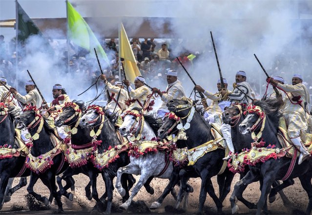 Horse riders perform during the historical equestrian representation called “Tabourida” in Bouznika, Morocco, 11 May 2023. The “Tabourida”, a UNESCO intangible cultural heritage, traditional Moroccan equestrian art, dates back to the 15th century AD. Its name goes back to the gunpowder fired by guns during the parade. It is a set of ceremonial rituals based on ancient principles and rules in most Moroccan regions, especially in areas of Bedouin nature. (Photo by Jalal Morchidi/EPA/EFE/Rex Features/Shutterstock)