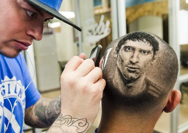 Hair artist and master barber Rob Ferrel (L), known as “Rob the Original”, cuts the likeness of Argentine soccer player Lionel Messi on the head of customer Vincent Hernandez, ahead of tomorrow's World Cup match between Argentina and Switzerland at his barbershop in San Antonio, Texas June 30, 2014. (Photo by Ashley Landis /Reuters)