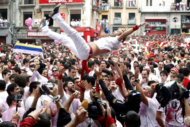 Revellers celebrate moments before the rocket fire or “Txupinazo” marks the start of the Festival of San Fermin (or Sanfermines) at Consistorio square in Pamplona, Spain, 06 July 2014. (Photo by Javier Lizin/EFE)