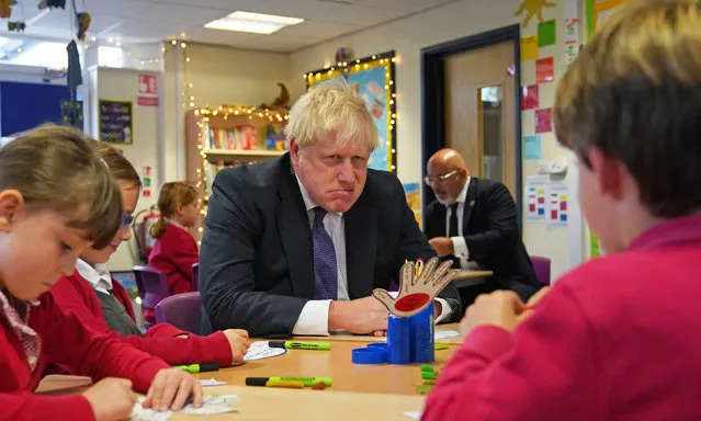 Britain's Prime Minister Boris Johnson interacts with school children during a visit to Westbury-On-Trym Church of England Academy in Bristol on October 15, 2021, ahead of chairing a regional cabinet meeting in the city later in the day. (Photo by Steve Parsons/Pool via AFP Photo)
