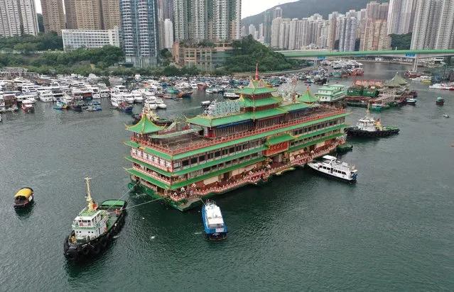 An aerial photo shows Hong Kong's Jumbo Floating Restaurant, an iconic but aging tourist attraction designed like a Chinese imperial palace, being towed out of Aberdeen Harbour on June 14, 2022, after its popularity dimmed in recent years even before the coronavirus hit. (Photo by Peter Parks/AFP Photo)