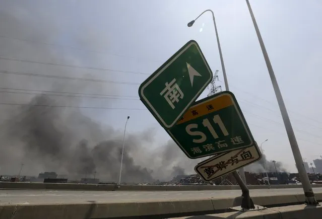 A damaged road sign is seen near the site of the explosions at the Binhai new district, Tianjin, August 13, 2015. (Photo by Jason Lee/Reuters)